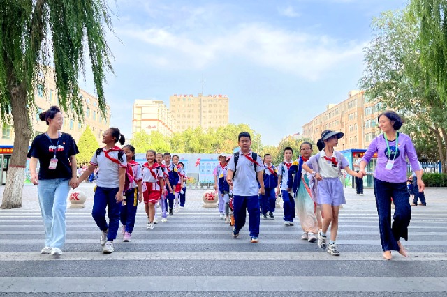 01 臨澤縣城關小學“紅燭先鋒”護學崗教師護送學生放學。謝靜 攝.jpg 01 臨澤縣城關小學“紅燭先鋒”護學崗教師護送學生放學。謝靜 攝.jpg