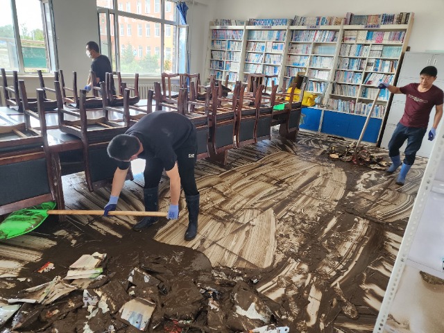 向陽鎮中心學校教師在清理淤泥。 李國彬 攝