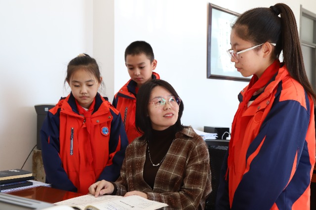 甘州區黨寨鎮中心學校教師在課間為孩子們講解疑難問題。（張儒泰攝）.JPG